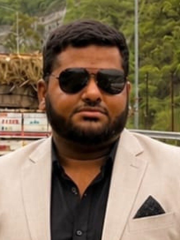 Raghav K Jha, manager at Sai Ram Developers, photographed in a light suit on a highway near the site.